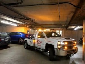 Busters Towing low-clearance wheel-lift extracting a vehicle from an underground parkade